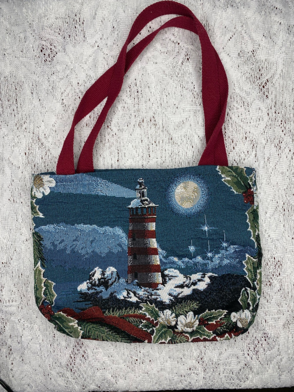 Thomas Kinkade tapestry tote bag featuring a coastal lighthouse scene.